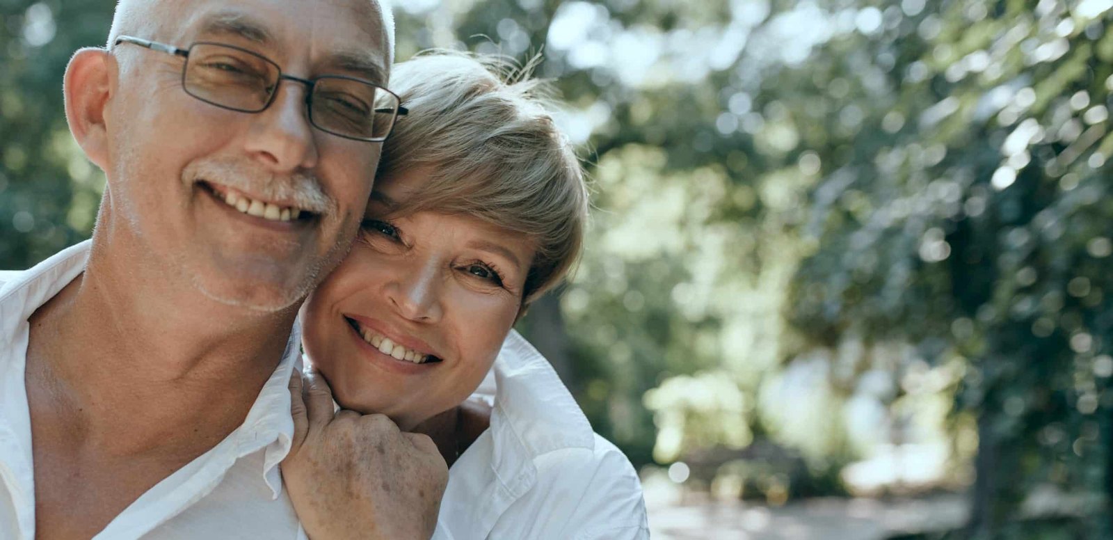 cheerful man with grey mustache modern shirt eyeglasses smiling posing with short haired lady white blouse outdoor 2